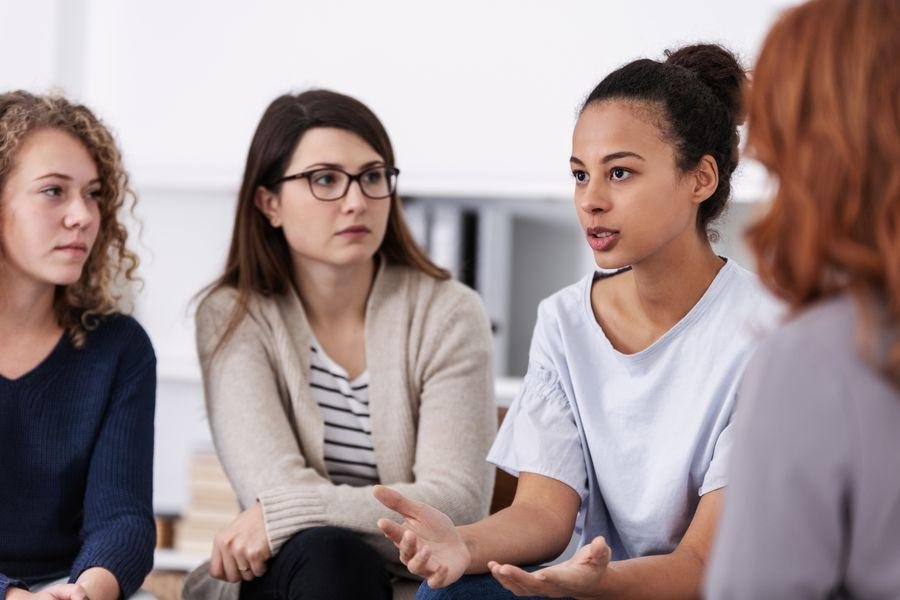 Frauen sitzen nebeneinander und sind im Gespräch Frauen sitzen nebeneinander und sind im Gespräch