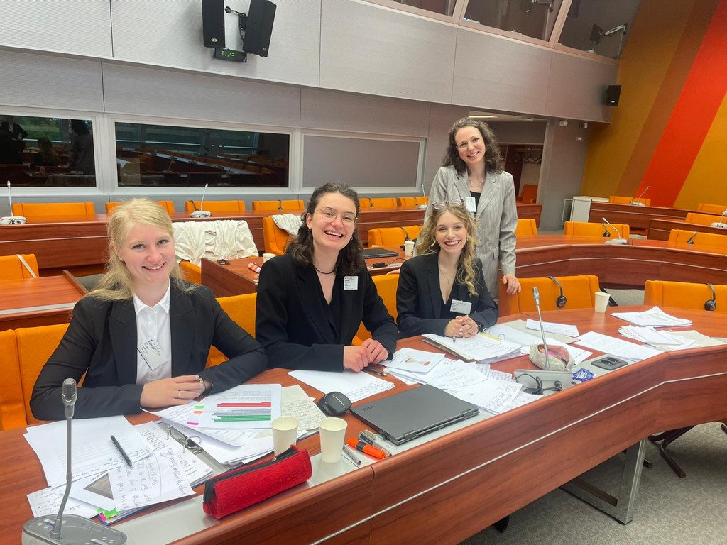Team auf ihren Plätzen im Saal