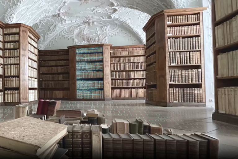 Symbolbild: Blick in den Stucksaal der Staatlichen Bibliothek in Passau. Auf dem Boden und auf Teilen des Bücherbestands werden Bitmuster eingeblendet.
