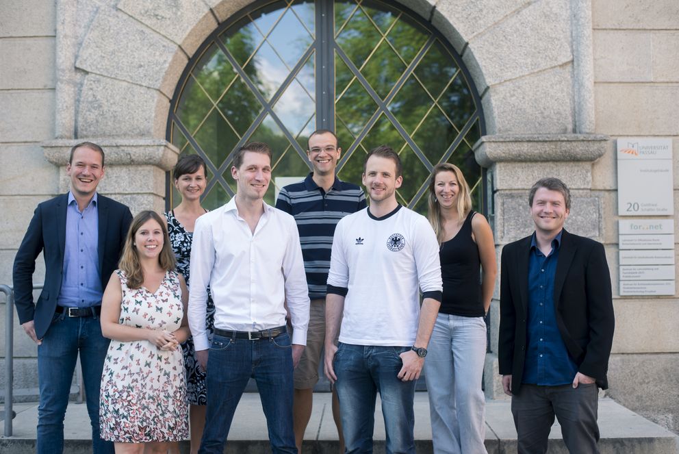 The current members of the RTG 'Privacy' with Co-ordinator Martin Scherer (left) and postdoctoral researcher Martin Hennig (right) in front of the entrance to the University's Institute Building.
