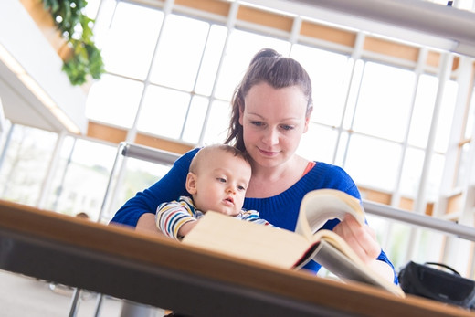 Eine Frau und ihr junges Kind beim Lesen in der Bibliothek